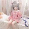 DD076 Eri 68cm TPE anime doll, sitting on a bed, waving with her right hand, showcasing her full body.